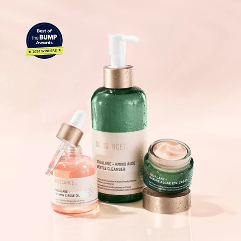Image 1 - A collection of three skincare products from Biossance, including a green gentle cleanser, a pink vitamin C rose oil, and a cream eye treatment, with a blue badge stating Best of the BUMP Awards 2024 WINNERS visible in the corner.
Image 2 - A bottle of Biossance Squalane + Vitamin C Rose Oil with a dropper, surrounded by droplets of water, accompanied by text indicating that 97% agree skin firmness is improved, 91% agree skin appears younger looking, and 91% agree skin has a healthy radiant glow, along with a badge stating Best of the BUMP Awards 2024 Winners.
Image 3 - Image shows a side-by-side comparison of a womans eye area before and after 21 days of product use, with visible wrinkles in the before image and smoother skin in the after image, accompanied by text stating 97% agree skin firmness and suppleness is improved.
Image 4 - A close-up image of several pink bottles of Biossance Squalane and Vitamin C Rose Oil, with visible text highlighting 2000+ ★★★★★ REVIEWS along with three customer testimonials about the products effectiveness.
Image 5 - Product image of Squalane + Marine Algae Eye Cream jar with cream on top, displaying text highlights: 97% showed improvement in the appearance of fine lines and wrinkles, 97% agree skin around eye area appears firmer after 1 use, 94% agree the look of dark circles improved after 1 week, Best of the BUMP Awards 2024 winners, and accepted by the National Eczema Association.
Image 6 - Image shows two close-up photos of an eye area, labeled Before on the left and After 14 Days on the right, illustrating reduced fine lines and wrinkles; additional text reads 97% showed improvement in the appearance of fine lines and wrinkles* based on a clinical study of 33 women.
Image 7 - A woman holds a jar of dark circle remover near her eye, smiling, with text overlay reading AMAZING! INSTANT DARK CIRCLE REMOVER, FINE LINES DISAPPEARED, AND MY EYES LOOK FIRMER AND LIFTED!
Image 8 - A green bottle of Biossance Squalane + Amino Aloe Gentle Cleanser with a pump lid sits on a light green background, surrounded by drops of the product, and includes text that states 100% showed significant removal of daily pollutants, 97% agree this product helped to remove daily makeup, and 97% agree their pores appear more refined and skin is softer and smoother, along with a footnote about the consumer study.